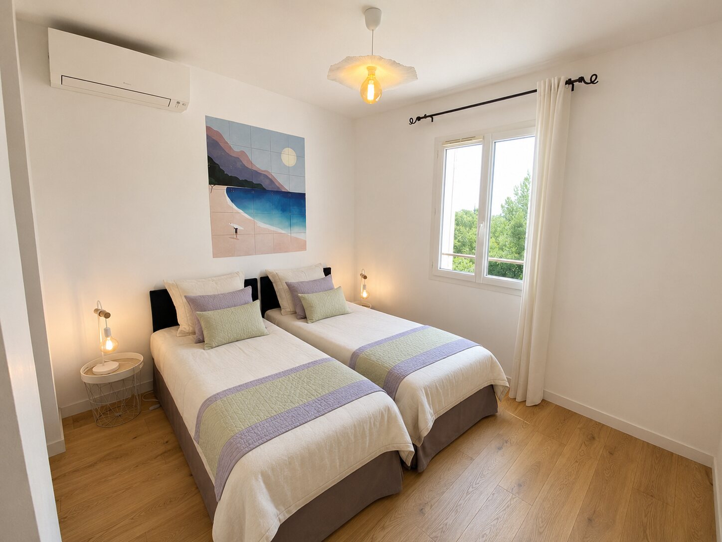 Chambre modulable à deux lits, décorée de sauge et de lavande pastel