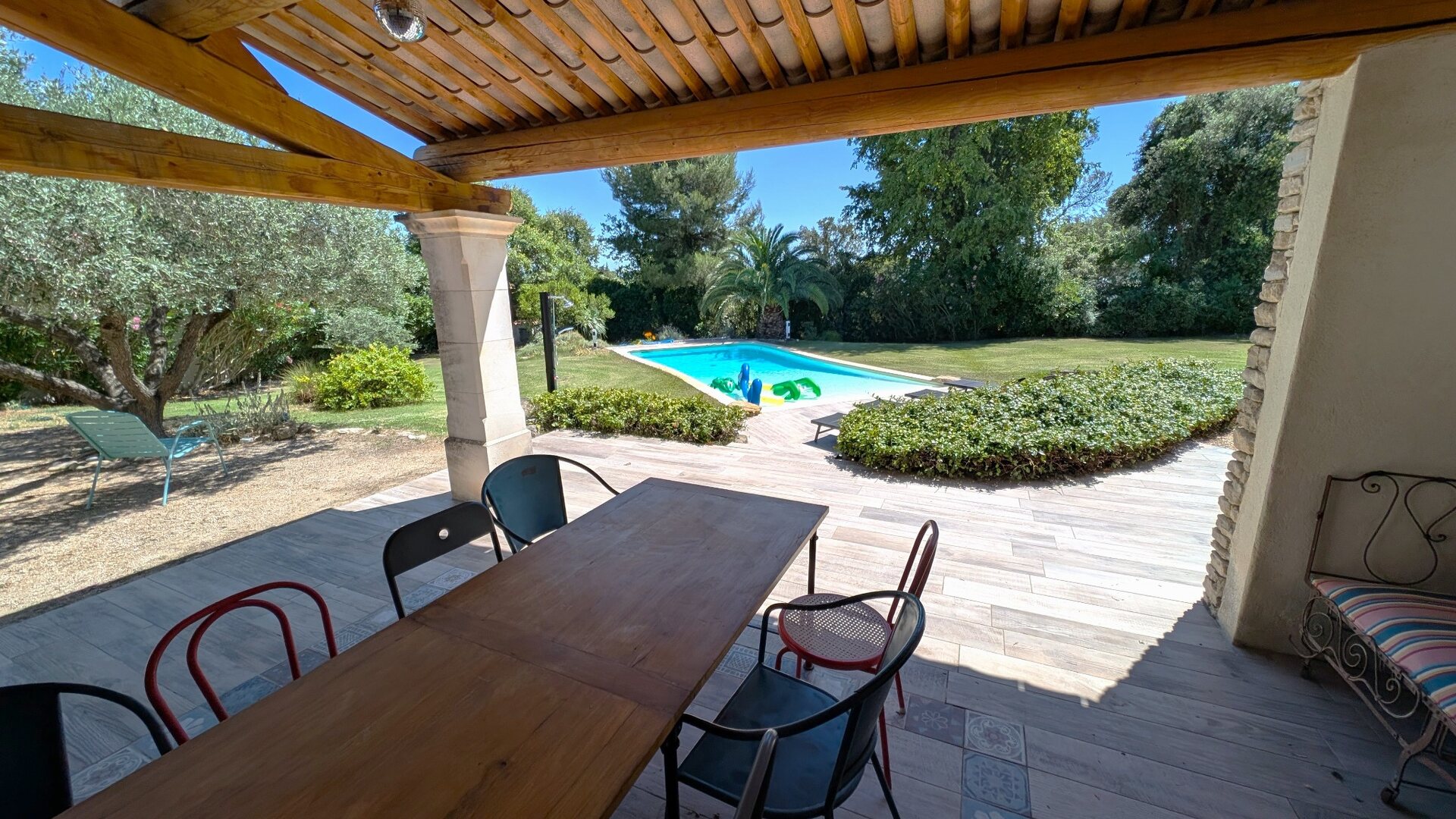 Grande table de la cuisine d’été ouverte sur la piscine et le jardin