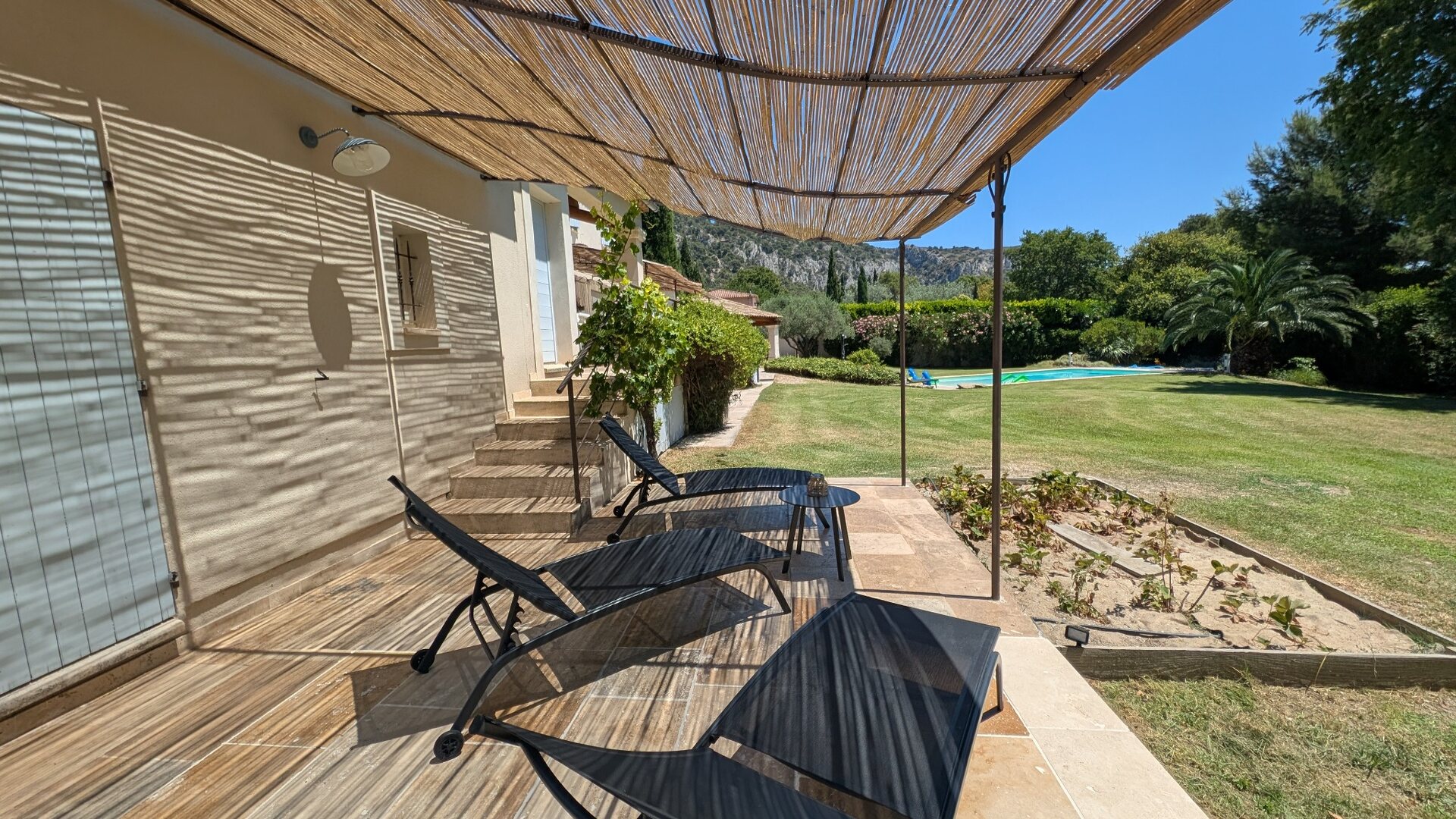 Transats sous les canisses face au jardin, à la piscine et au Petit Luberon